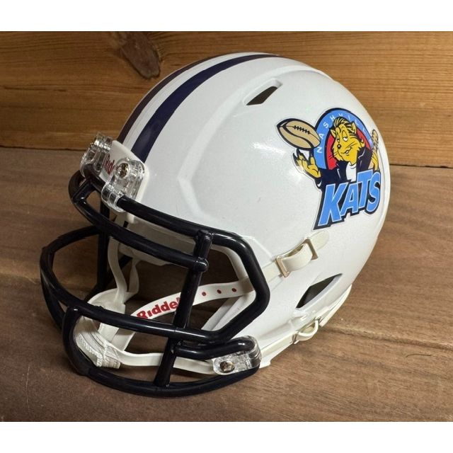 Nashville Kats Throwback Mini Helmet. White shell with a navy center stripe and navy facemask. Cartoon cat holding a football on the side, with NASHVILLE arched above in blue and KATS in large blue letters below.