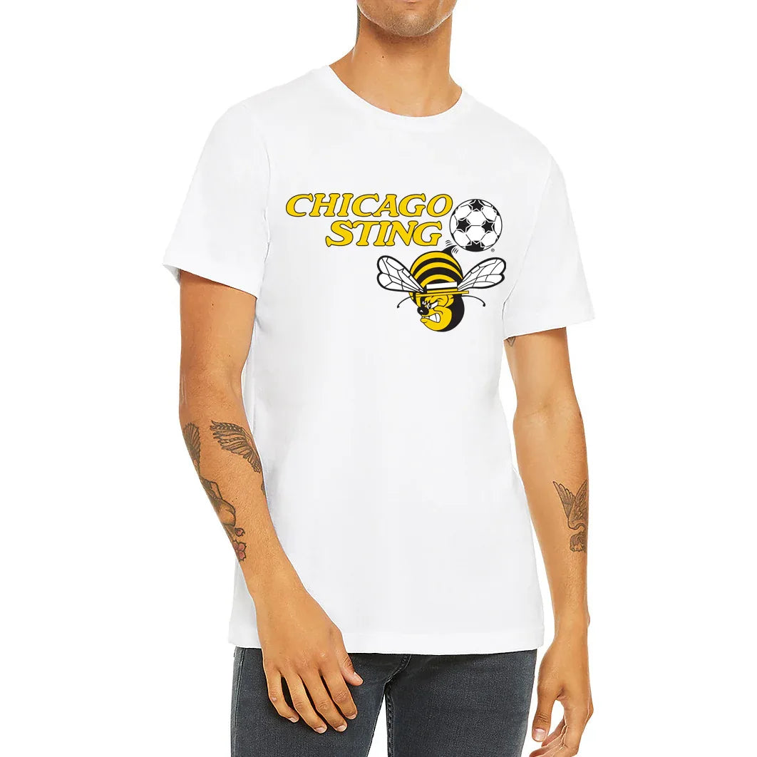Chicago Sting T-shirt white. "Chicago" slightly over "Sting" to the left in gold. Black and white soccer ball to the right with angry cartoon be with white wings below. Royal Retros.