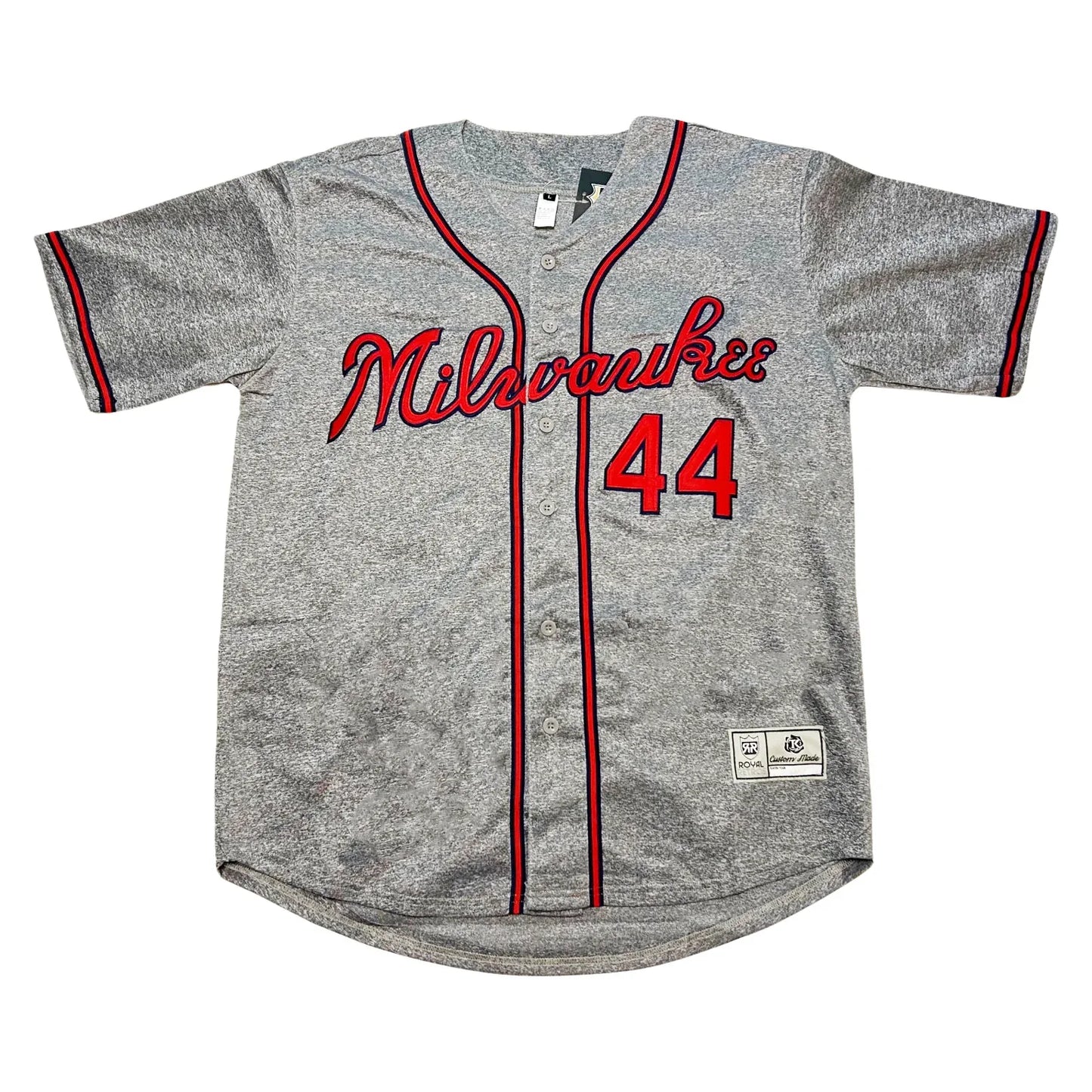 Milwaukee Braves button-up baseball jersey. Pepper gray. Milwaukee in cursive in red with blue trim across chest. #44 lower right in red with blue trim. Blue, red, and blue stripe around sleeve ends, around neck and down front on both sides of buttons. Royal Retros
