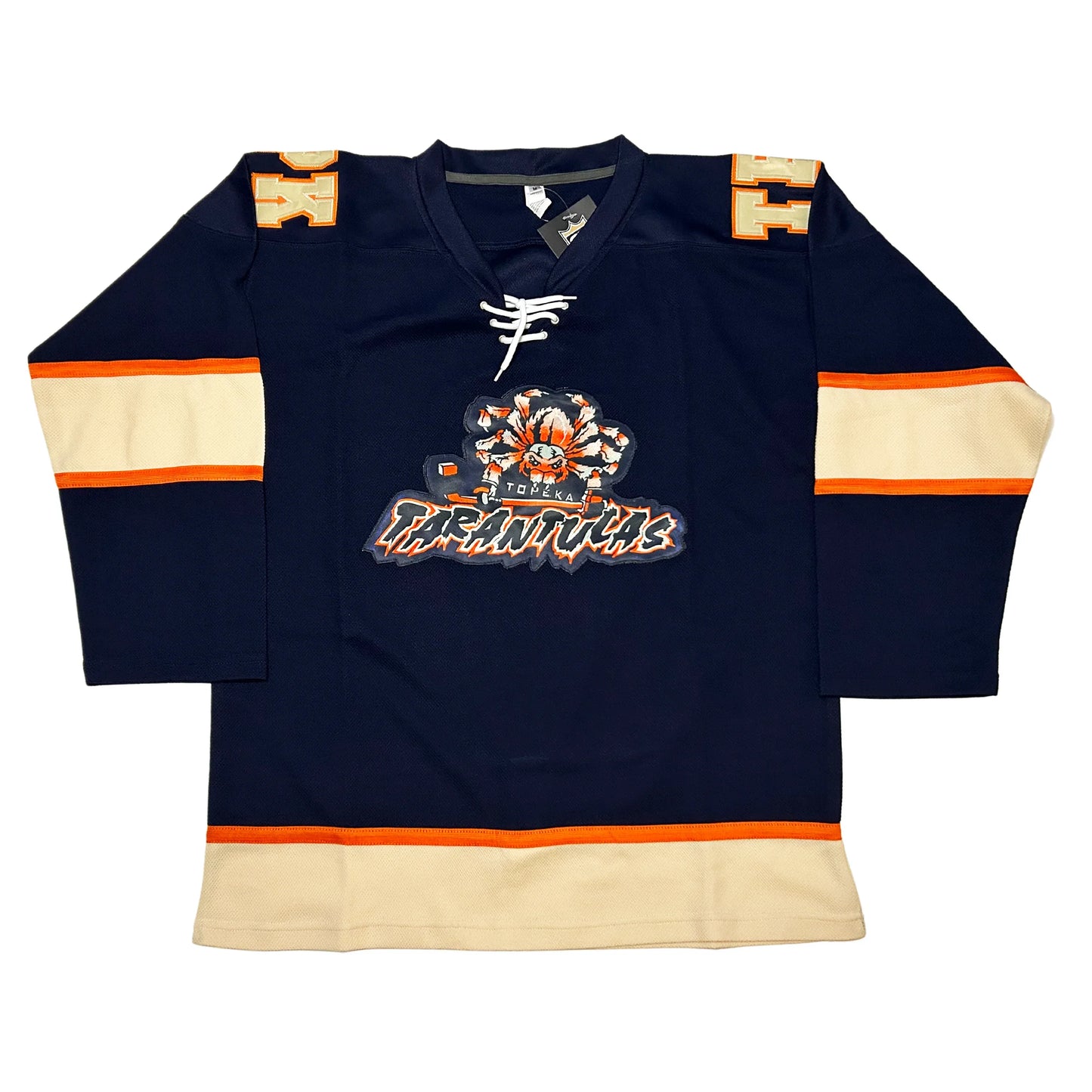 Topeka Tarantulas hockey Jersey Navy. Thin orange, thick white, thin orange bands mid-sleeve. Thin orange, thick white band at waist. Blue, orange and white spider holding hockey stick above stylized TATANTULAS in blue with orange trim and white shadow. Royal Retros