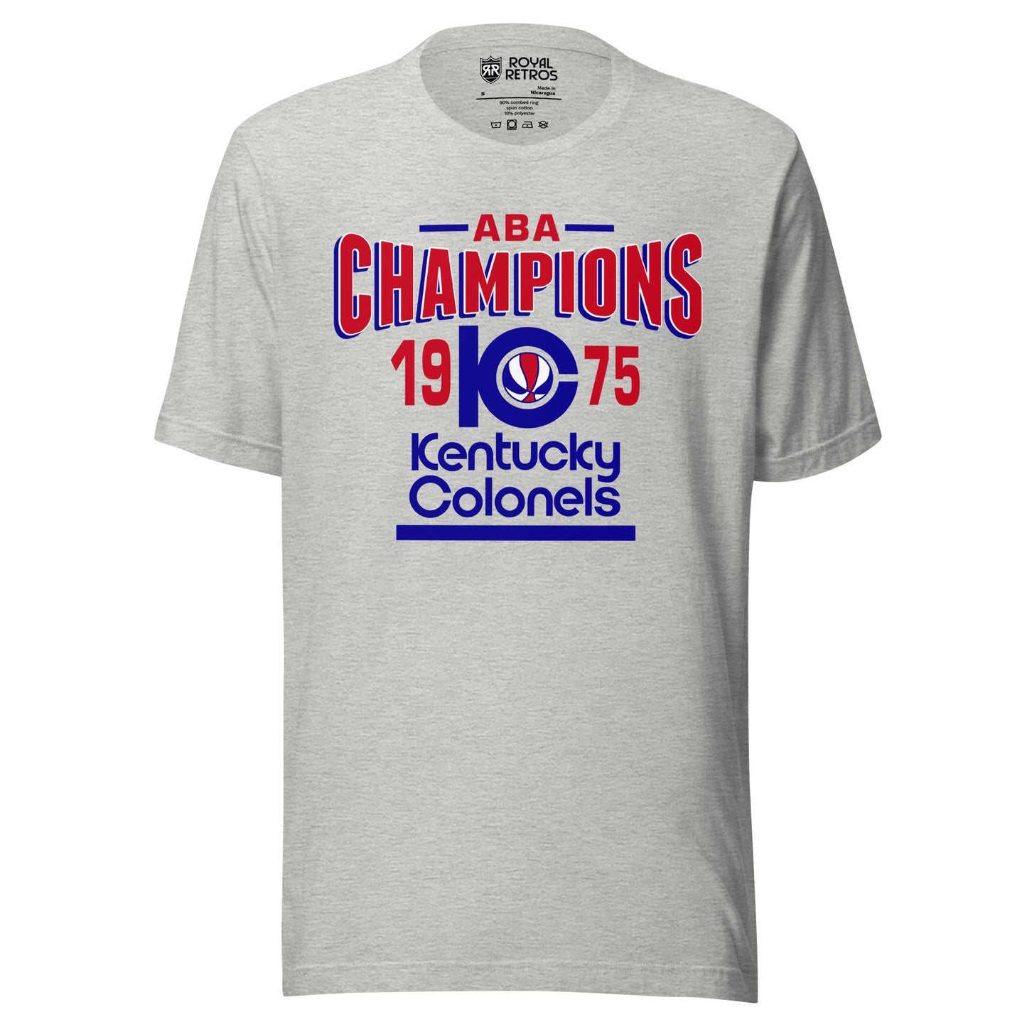 Kentucky Colonels ABA 1975 Champions T-shirt. Gray. ABA in red with blue lines on either side. Champions in red bent in in center/ K with C coming out of it and red, white, and blue basketball inside. 19 in red to the left pf the KC and 75 to the right. Kentucky in blue below, Colonels in blue below that, blue line below that. Royal Retros