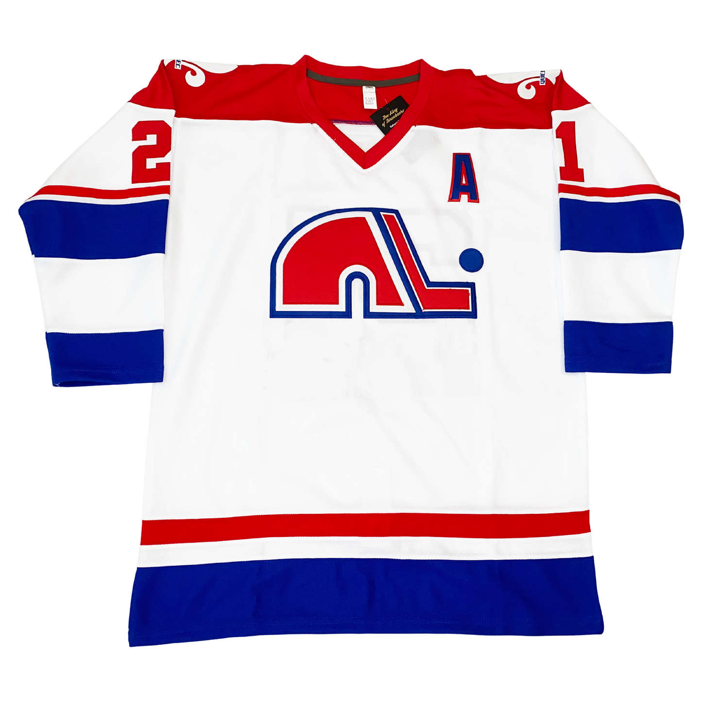 WHA Nordiques Jersey 1974 white. Red shoulders and collar. Thin red and white band above large blue, white and blue bands on sleeves. #21 in red on shoulders. Red, white, and larger blue band on waist. fleur-de-lis in white on shoulders. Red N lowercase logo with white and blue trim. Red hockey stick to right of letter with blue and white trim, blue puck above blade. Alternate captain "A" on upper left chest. Royal Retros