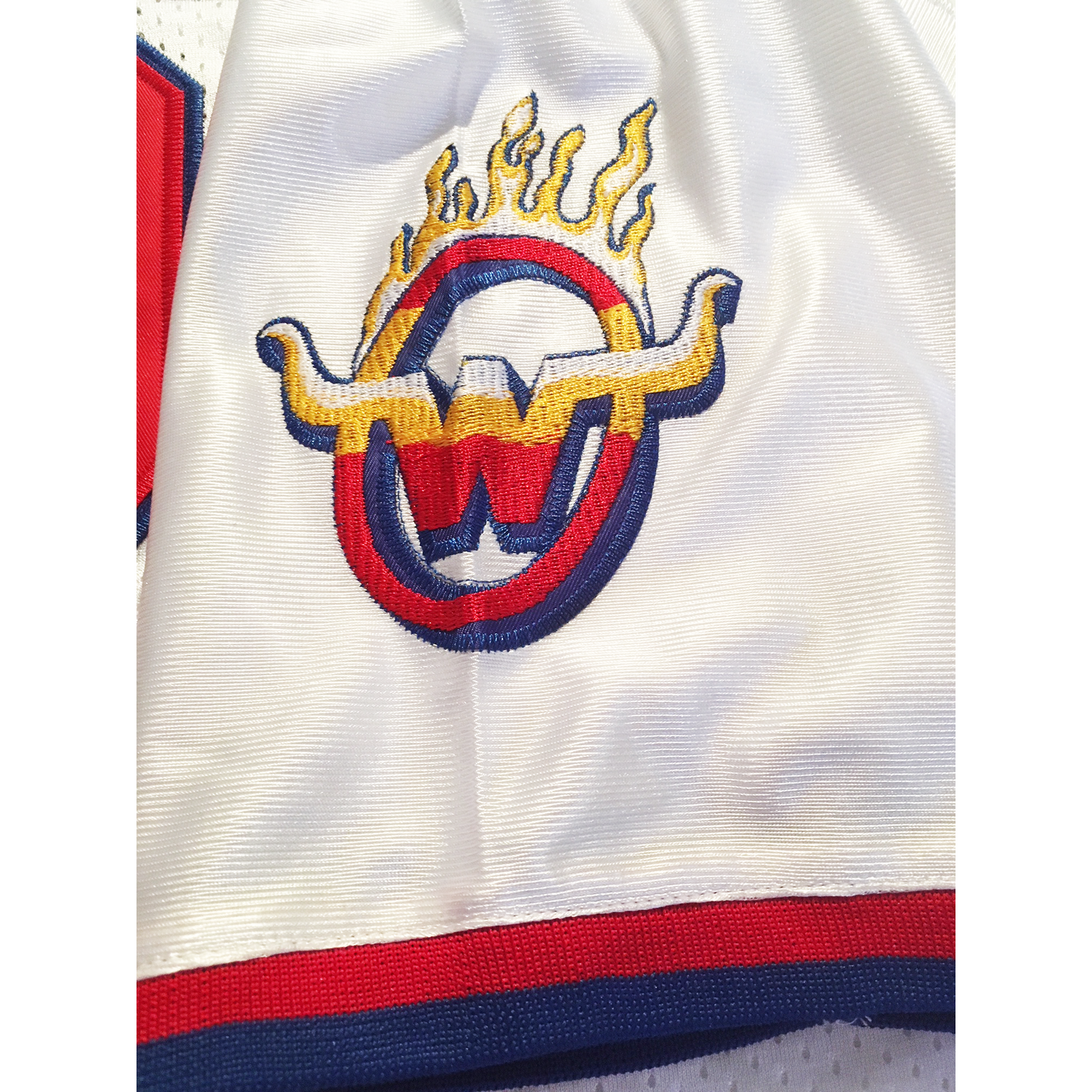 Arizona Wranglers 1984 USFL Jersey white close-up of W brand logo, consisting of W with wings in a circle with flames on top on white sleeve. Royal Retros
