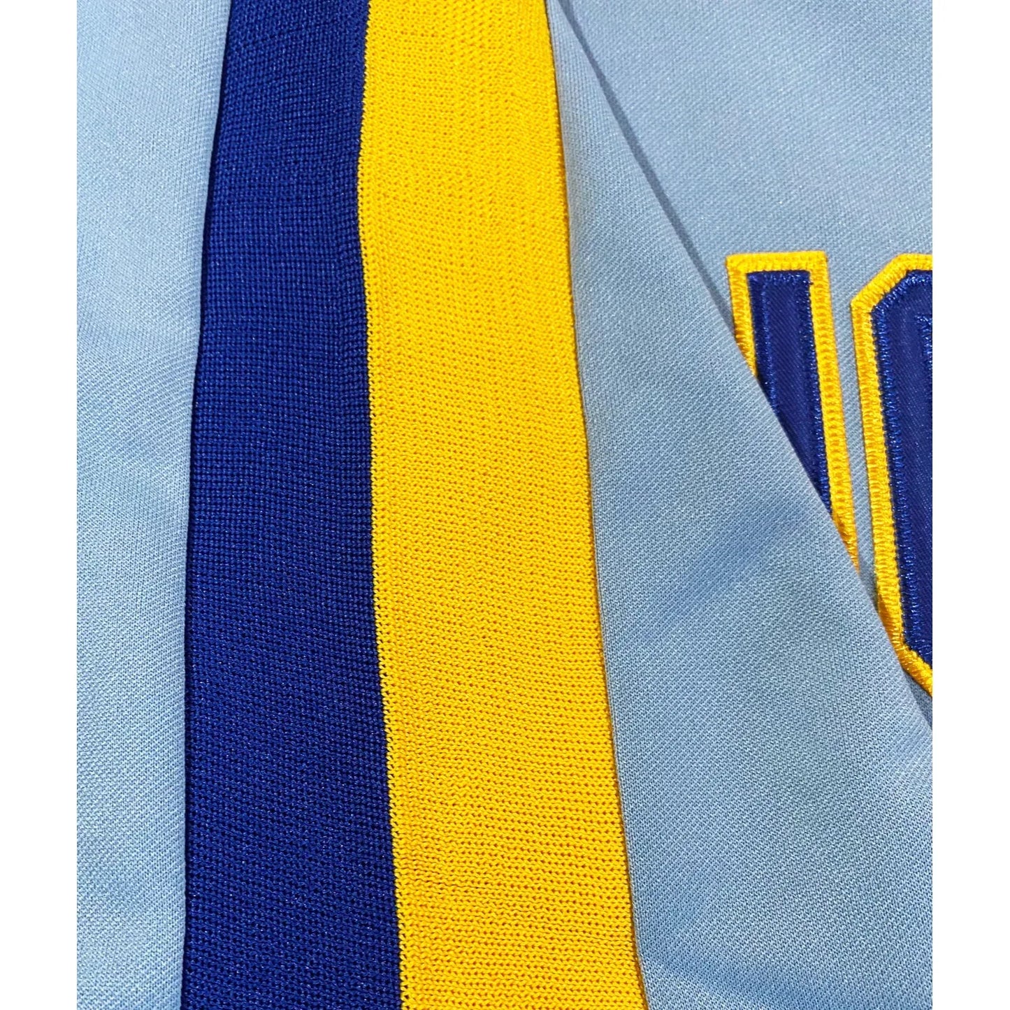 Bellingham Mariners Jersey light blue. Navy and gold trim on shoulders close-up. Royal Retros