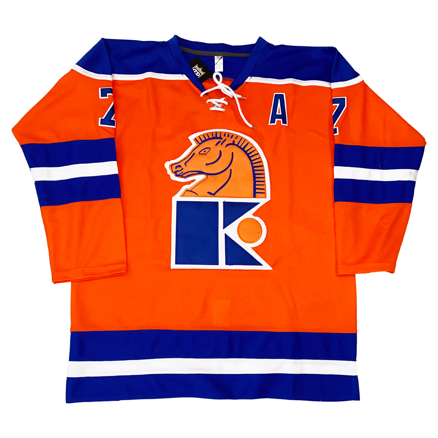 Jersey Knights hockey jersey orange. Blue shoulders with white trim. Blue, white, and blue bands mid-sleeve and around waist. Horses head in orange with blue detail looking left over blue K with white trim and orange circle to the right. Co-captain A in blue with white trim on left chest. Royal Retro