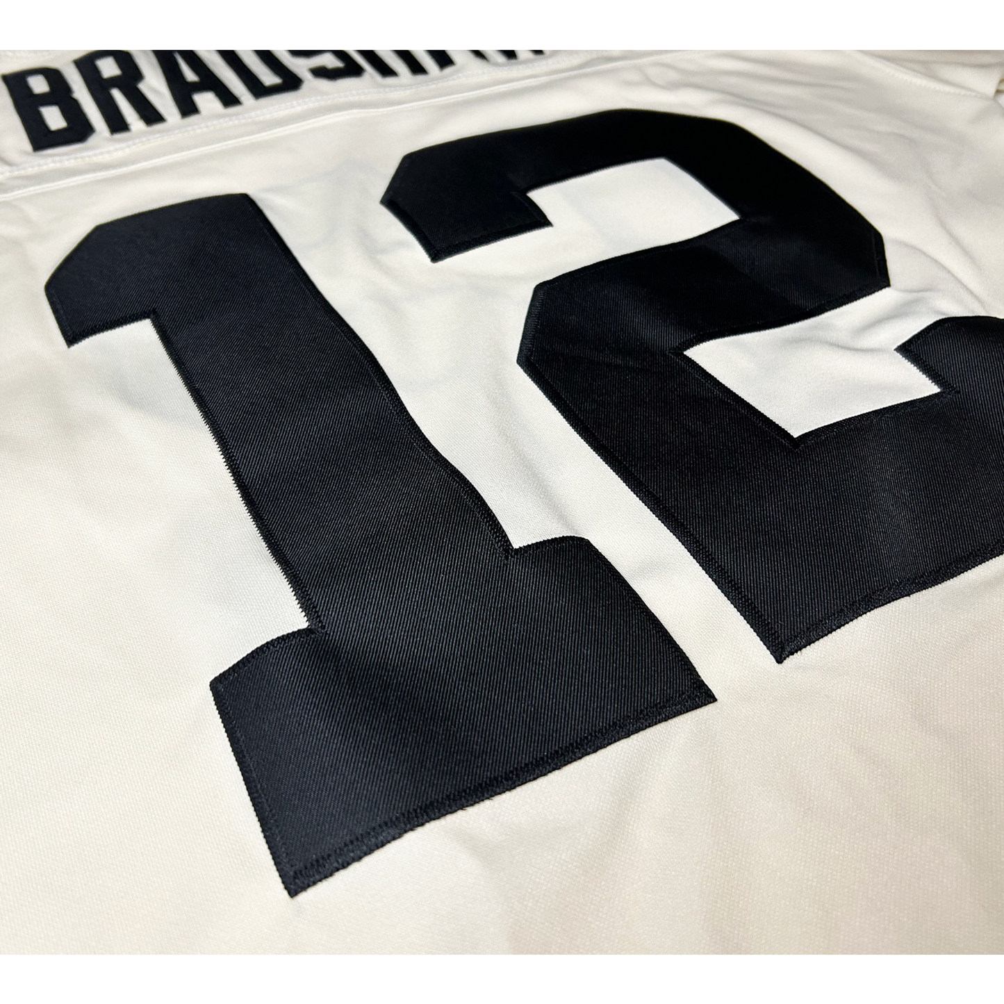 Pittsburgh Steelers cream jersey. Cream. Close-up of #12 in black, Bradshaw above. Royal Retros