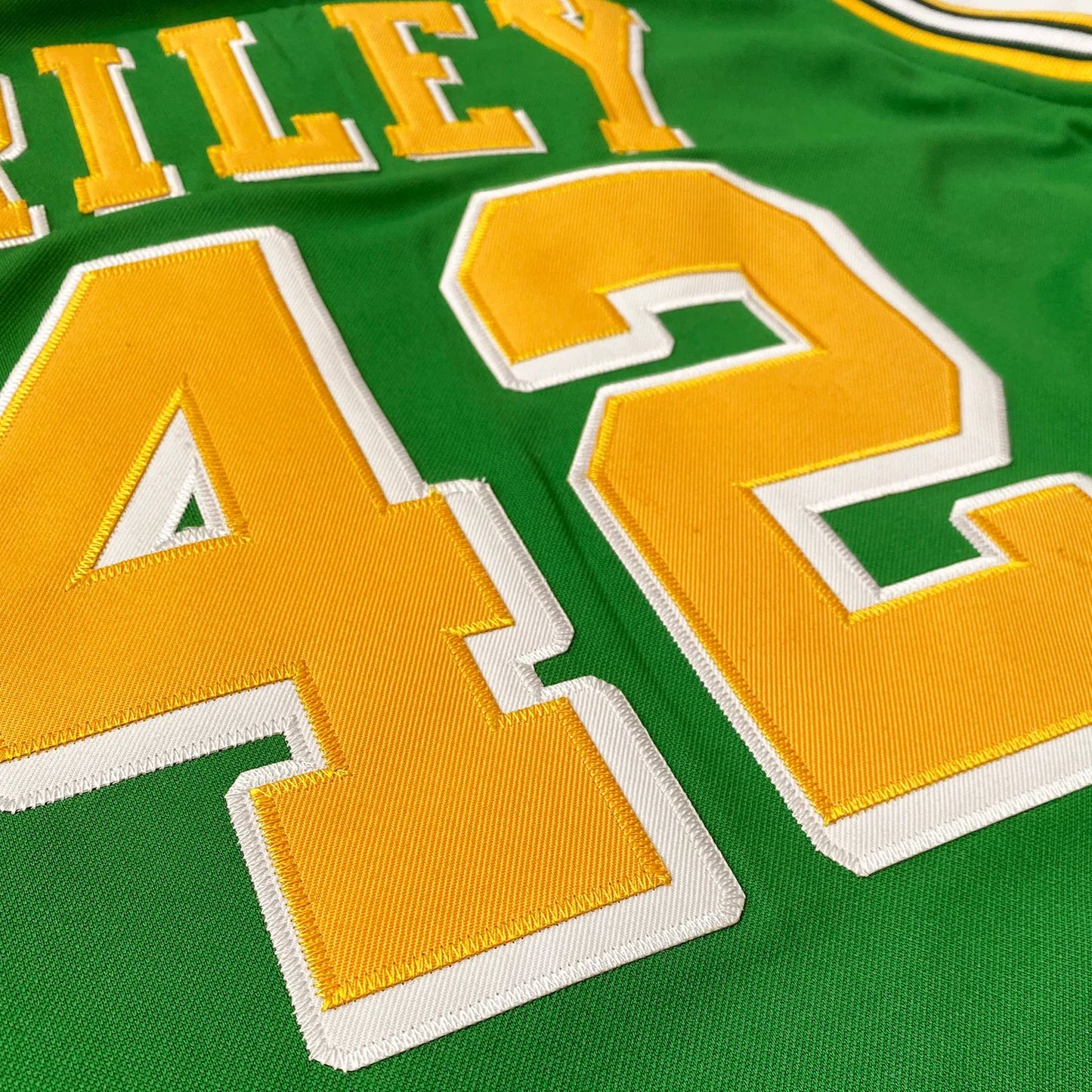 san diego rockets jersey green with yellow, white, and green trim on neck and shoulders. Close-up, #42 yellow with white trim, Riley in yellow with white trim above numbers. Royal Retros