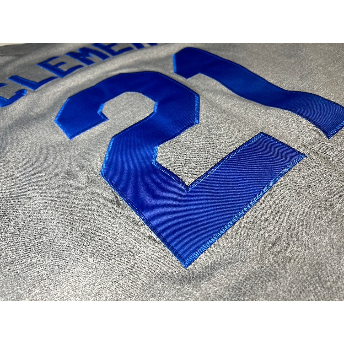Santurce Cangrejeros Jersey close-up. Pepper gray with blue #21 and Clemente above also in blue. Royal Retros.