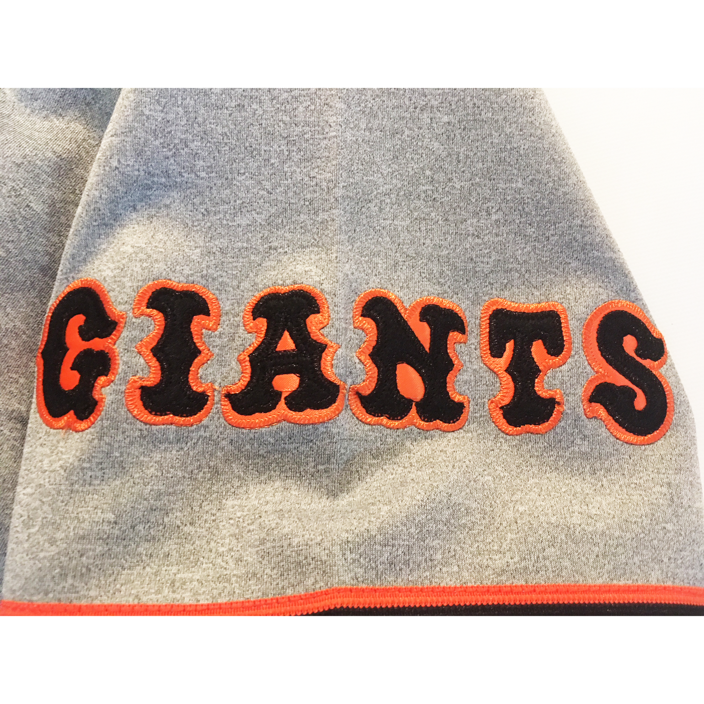 Tokyo Giants Jersey close up of stylized Giants in black with orange trim on sleeve. Royal Retros