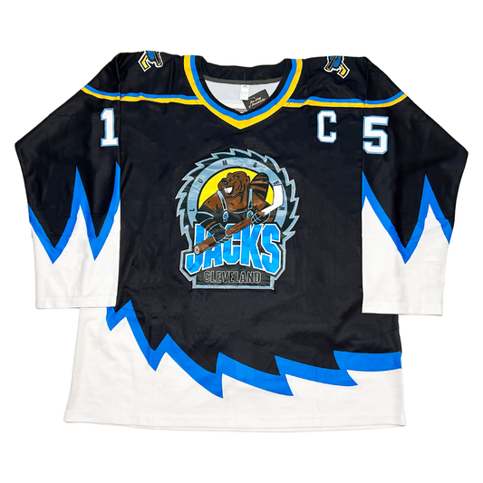 1999 Cleveland Lumberjacks jersey. Black. Jagged cut blue trim with white below on sleeves and waist. Lumberjacks logo in center consisting of crcular saw blade with beaver holding hoekcy stick in center on a yellow background. Jacks in blue under beaver/ #15 in white with blue trim on sleeves. Royal Retros onlime.