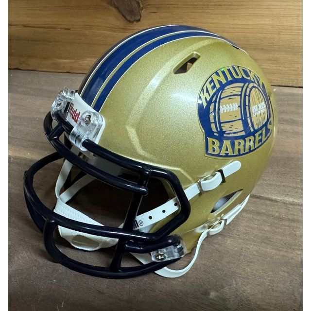Kentucky Barrels Mini Helmet. Metallic gold shell with double navy stripes and a navy facemask. Barrel-shaped logo on the side with KENTUCKY arched above in navy and BARRELS below, red football-barrel icon in the center.