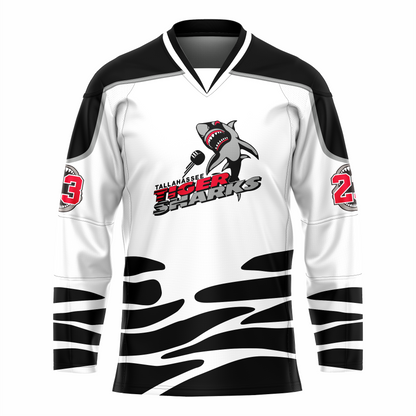 Tallahassee Tiger Sharks hockey jersey. White. Black and white collar, black shoulders with silver trim. Random black pattern at sleeve ends and around waist suggesting ocean waves. Logo is a shark swimming toward viewer with Tallahassee small in black with white trim above Tiger  in red and Sharks in silver. Royal Retros