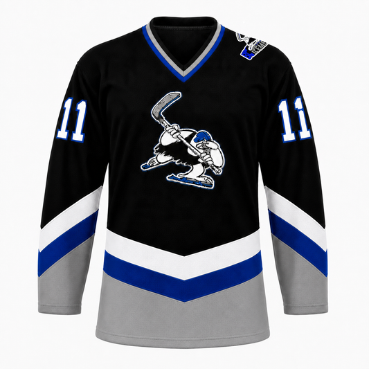 B.C. Icemen hockey jersey front in black with grey lower body, blue and white chevron striping, and the cartoon penguin mascot crest at center chest