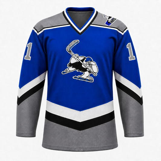 B.C. Icemen hockey jersey front in royal blue with grey shoulders and lower body, black and white chevron striping, and the cartoon penguin mascot crest at center chest