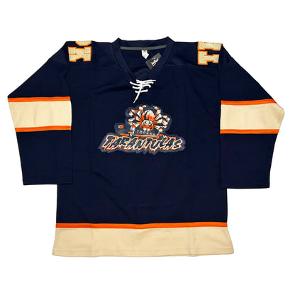 Topeka Tarantulas hockey Jersey Navy. Thin orange, thick white, thin orange bands mid-sleeve. Thin orange, thick white band at waist. Blue, orange and white spider holding hockey stick above stylized TATANTULAS in blue with orange trim and white shadow. Royal Retros