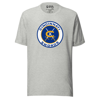 Cincinnati Swords AHL hockey T-shirt. Gray. Thick white circle with blue background. Cincinnati in blue arched in top of circle Swords arched up in circle below. Gold C in center with two swords with gold handles crossed behind it. Royal Retros