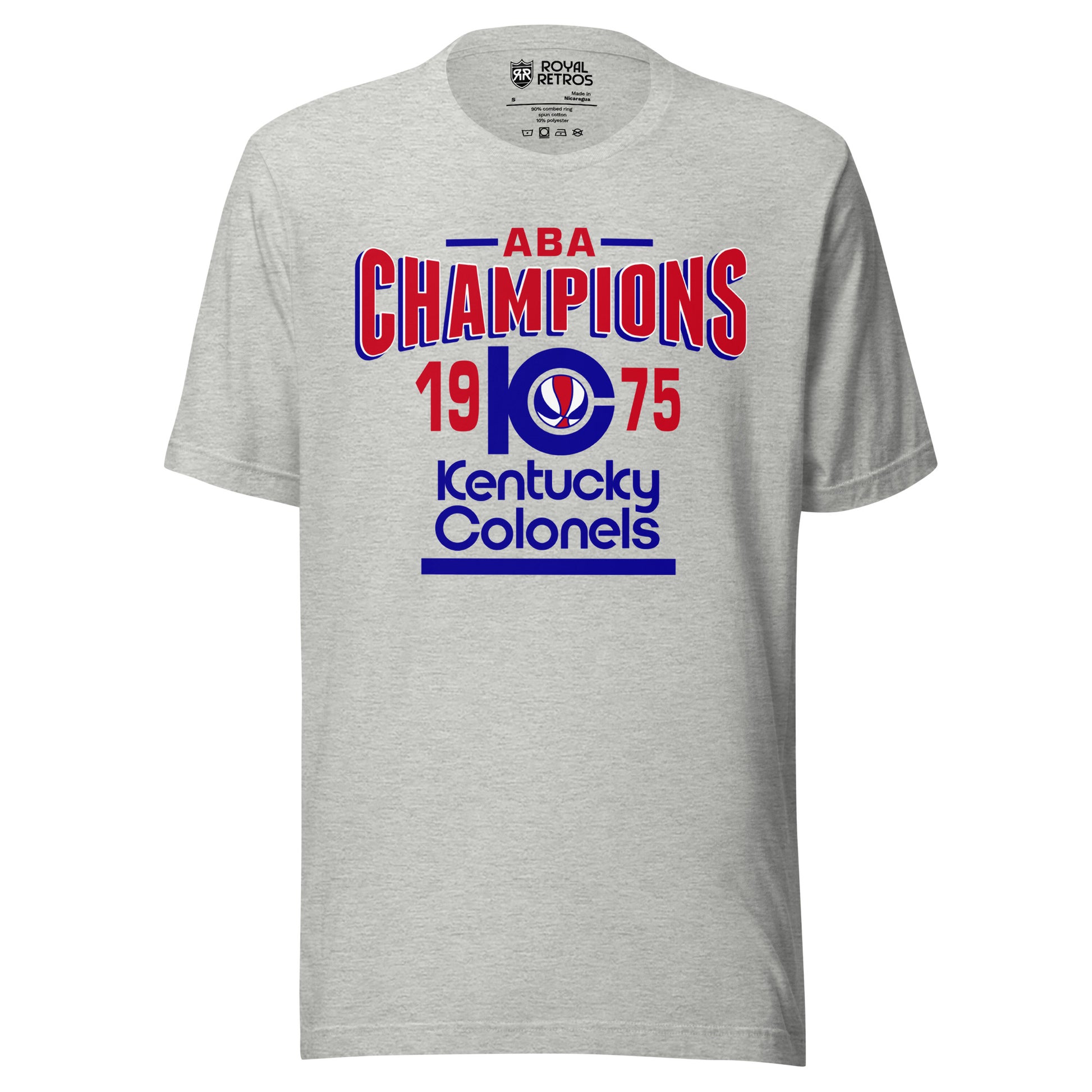 Kentucky Colonels ABA 1975 Champions T-shirt. Gray. ABA in red with blue lines on either side. Champions in red bent in in center/ K with C coming out of it and red, white, and blue basketball inside. 19 in red to the left pf the KC and 75 to the right. Kentucky in blue below, Colonels in blue below that, blue line below that. Royal Retros