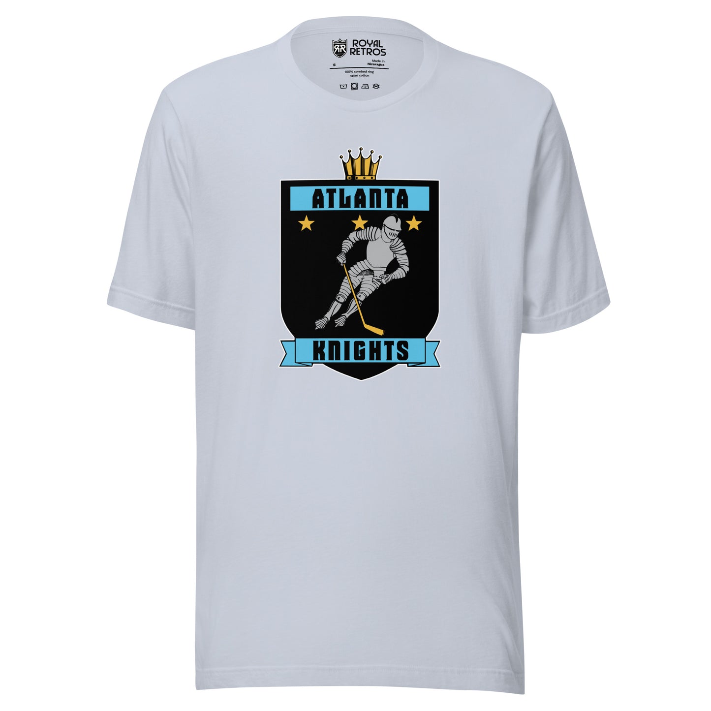 Atlanta Knights hockey T-shirt. Light Blue. Black shield with small gold crown on top. Blue band inside top with ATLANTA in black. 3 gold stars below that. Knight with hockey stick skating leaning right. Blue banner with Knights below bottom if shield. Royal Retros. 