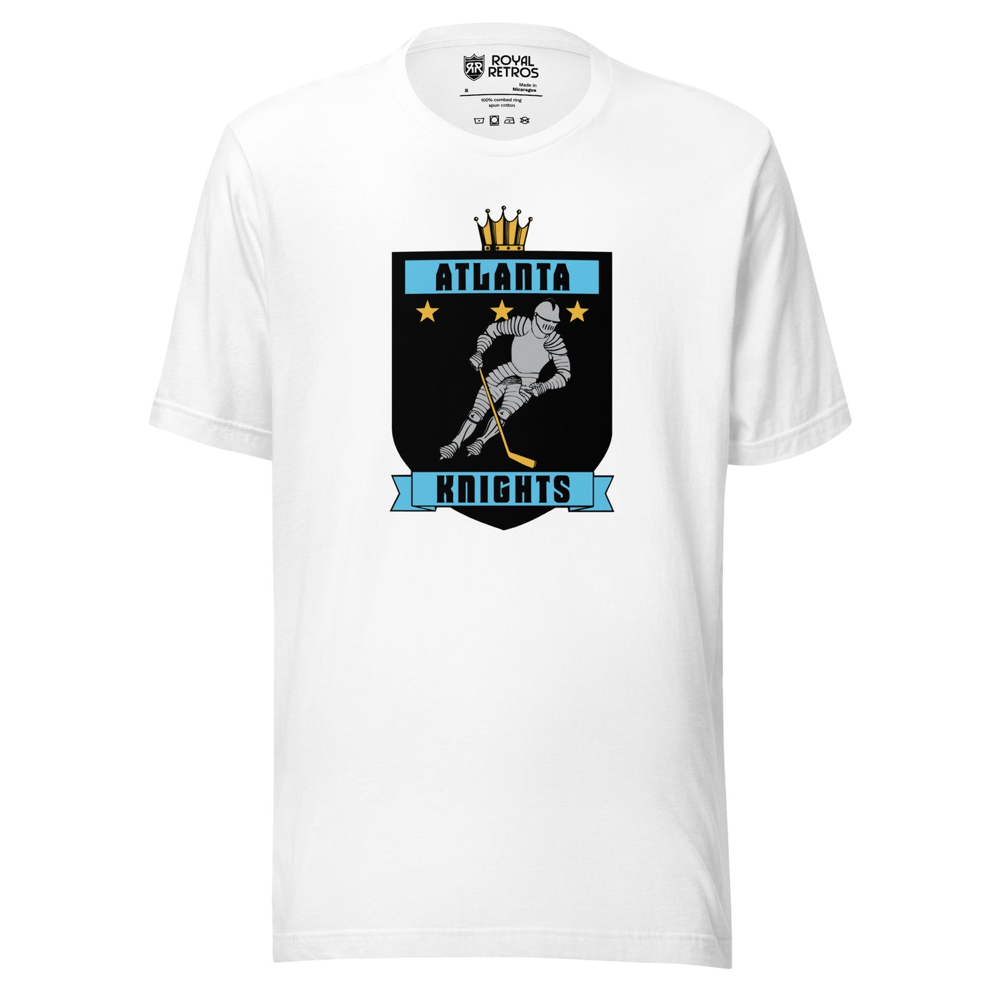 Atlanta Knights hockey T-shirt. White. Black shield with small gold crown on top. Blue band inside top with ATLANTA in black. 3 gold stars below that. Knight with hockey stick skating leaning right. Blue banner with Knights below bottom if shield. Royal Retros. 