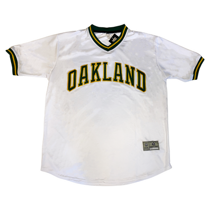 Oakland A's baseball jersey white. Green and yellow trim on neck and sleeves. Oakland in green with yellow trim across chest. Royal Retros