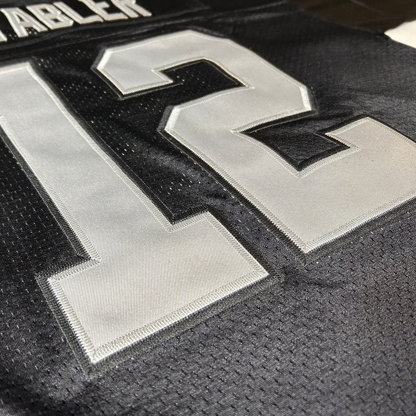 Oakland Raiders jersey close-up black, white #12 and white lettering, Stabler, above numbers. Royal Retros
