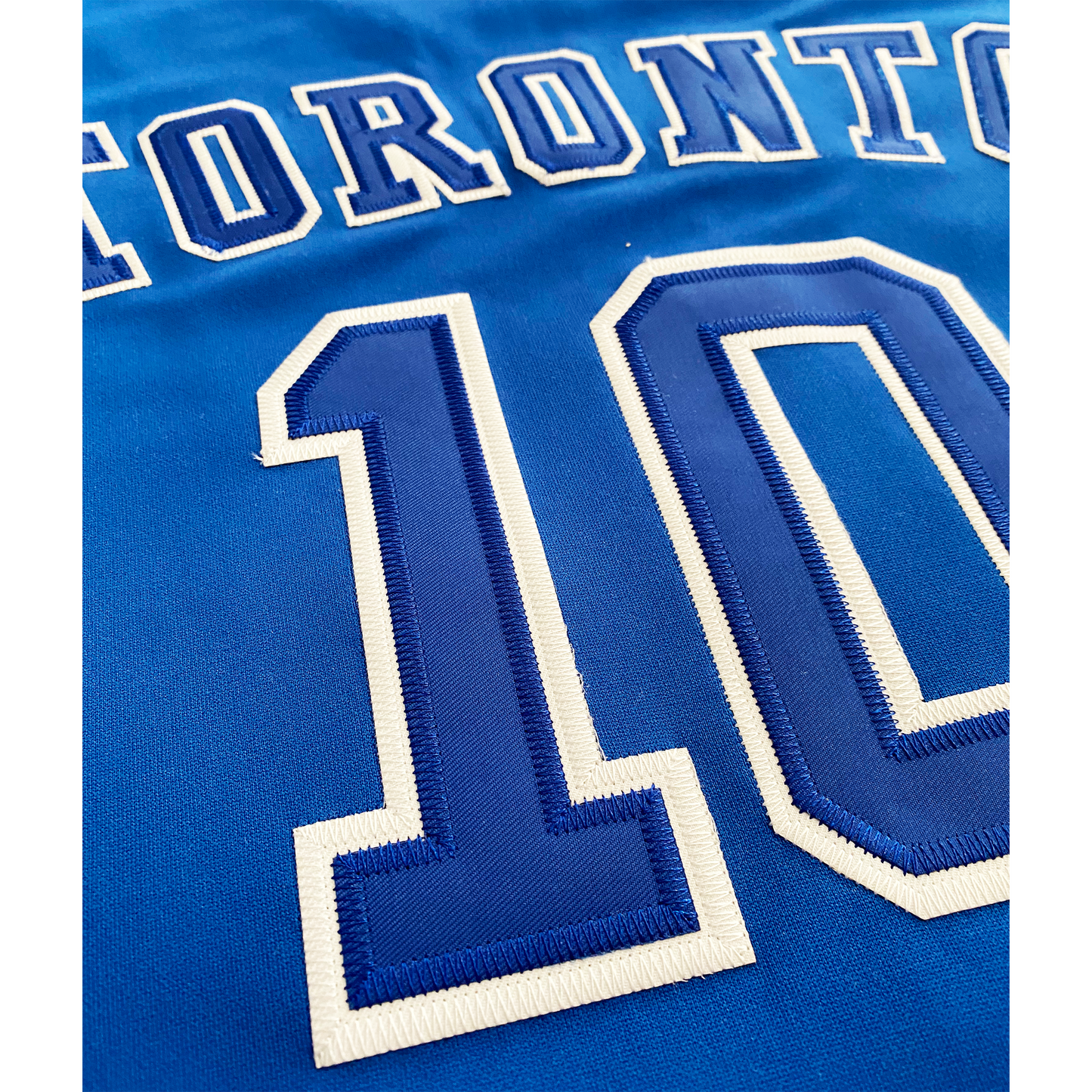 Toronto Huskies blue basketball jersey close-up.TORONTO outlined in white arched across chest. #10 outlined oin white, large on chest. Royal Retros